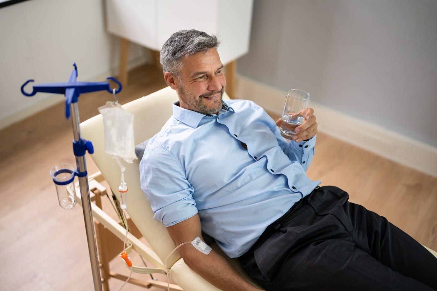 Men Holding Glass and Receiving IV Therapy | Synergy Wellness MediSpa in Red Bank, NJ