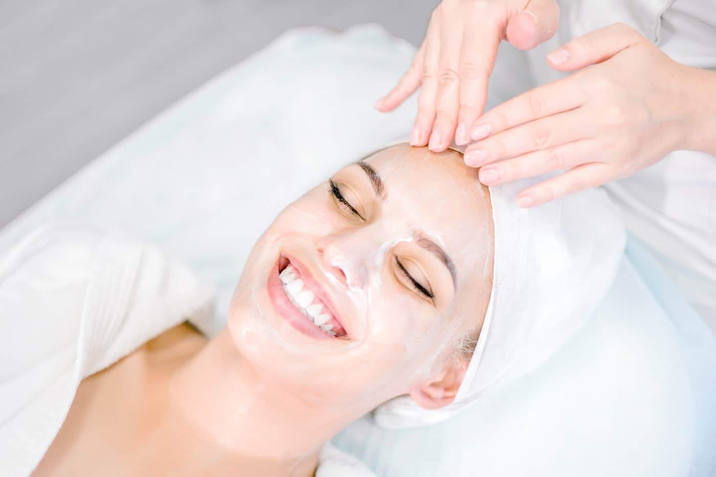 Beautician Makes Facial Massage With Mask on Smiling Girl's Face | Synergy Wellness MediSpa in Red Bank, NJ