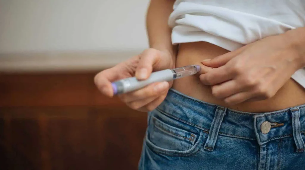 a person injecting insulin into her stomach