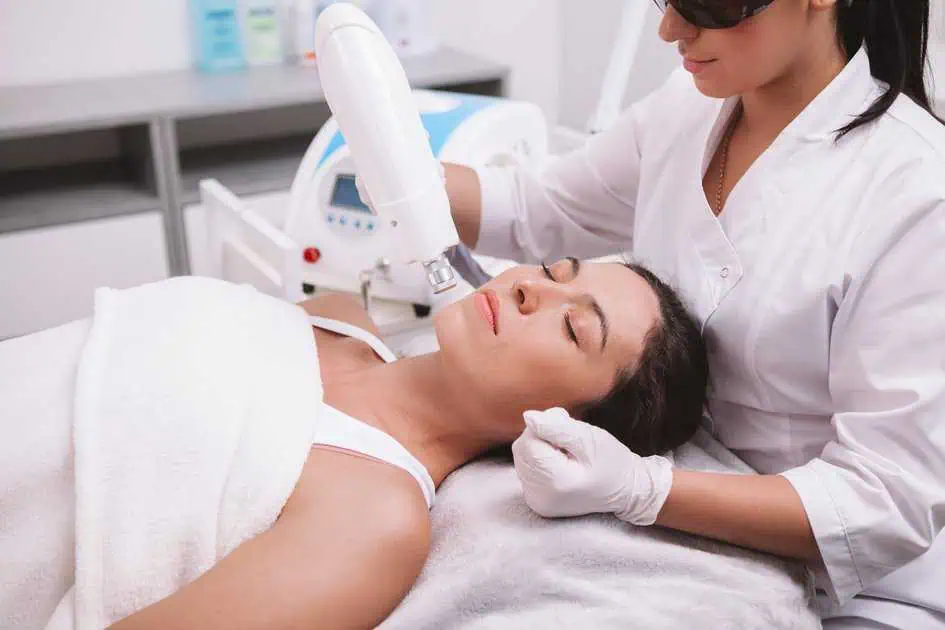 a woman lying down on a bed with a device on her face