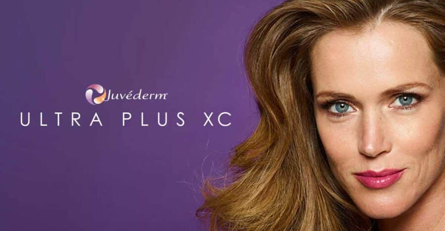 a woman smiling with a purple background - Juverderm XC | Synergy Wellness MediSpa in Oceanport, NJ